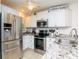 Well-lit kitchen features stainless steel appliances, white cabinets, and granite countertops at 29147 Bay Hollow Dr # 3217, Wesley Chapel, FL 33543