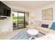 Bright living room features a plush sectional, coffee table, and sliding glass doors to outdoor view at 29147 Bay Hollow Dr # 3217, Wesley Chapel, FL 33543