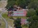 Aerial view of community tennis and playground area surrounded by lush trees and winding sidewalks at 2963 Cielo N Cir, Clearwater, FL 33759