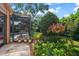 Lush backyard with screened-in pool, mature trees, and beautiful hanging flower baskets at 2963 Cielo N Cir, Clearwater, FL 33759