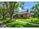 Well-maintained home showcases lush landscaping and a serene setting with mature trees and green lawn at 2963 Cielo N Cir, Clearwater, FL 33759