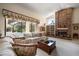 Cozy living room with a brick fireplace, comfortable seating, and views of the screened-in pool area at 2963 Cielo N Cir, Clearwater, FL 33759