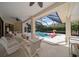 Inviting covered patio with dining furniture overlooking a screened pool and spa with lush landscaping at 2963 Cielo N Cir, Clearwater, FL 33759