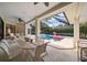 Inviting covered patio with dining furniture overlooking a screened pool and spa with lush landscaping at 2963 Cielo N Cir, Clearwater, FL 33759