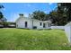 Large backyard showing green grass, white fence, and AC unit at 3016 N 73Rd St, Tampa, FL 33619
