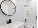 Modern bathroom features a walk-in shower, round mirror, and black hardware at 3016 N 73Rd St, Tampa, FL 33619