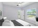 Bright bedroom features a ceiling fan, a large window, and neutral wall and floor tones at 3016 N 73Rd St, Tampa, FL 33619