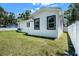 Side view of the white home showing the green lawn and gray trim at 3016 N 73Rd St, Tampa, FL 33619