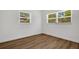 Bright bedroom featuring wood-look floors, two large windows, and fresh white walls at 3151 6Th S Ave, St Petersburg, FL 33712
