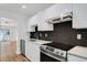 Modern kitchen featuring stainless steel appliances, sleek white cabinets, and black tiled backsplash at 3151 6Th S Ave, St Petersburg, FL 33712