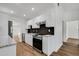 Modern kitchen with sleek white cabinets, stainless steel appliances, black backsplash, and stylish wood flooring at 3151 6Th S Ave, St Petersburg, FL 33712