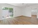 Bright living room with white walls, wood-look floors, and view into another room at 3151 6Th S Ave, St Petersburg, FL 33712