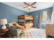 Charming bedroom with blue walls, bunk beds, chair and a decorative rug at 3219 Centerwood Dr, Tarpon Springs, FL 34688