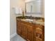 Bathroom vanity featuring granite countertop, wood cabinets, and modern fixtures at 322 Windrush Loop # 22, Tarpon Springs, FL 34689