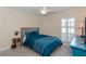 Comfortable bedroom with a cozy blue bed, bedside table, and shuttered windows at 322 Windrush Loop # 22, Tarpon Springs, FL 34689