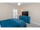 This bedroom features neutral walls, a blue accent dresser with a tv, and plantation shutters at 322 Windrush Loop # 22, Tarpon Springs, FL 34689