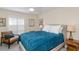 Cozy bedroom with a comfortable bed, accent chair, and shuttered windows at 322 Windrush Loop # 22, Tarpon Springs, FL 34689