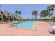 Community pool with a brick deck, surrounded by lounge chairs with ocean views at 322 Windrush Loop # 22, Tarpon Springs, FL 34689