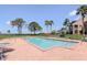 Community pool featuring a lounge area and view of the ocean beyond the fence at 322 Windrush Loop # 22, Tarpon Springs, FL 34689