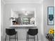 Bar seating area overlooking the kitchen, featuring granite countertops and stylish bar stools at 3399 Mermoor Dr # 301, Palm Harbor, FL 34685