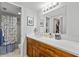 Bright bathroom with a large mirror, vanity with storage and a shower and tub combo behind a curtain at 3399 Mermoor Dr # 301, Palm Harbor, FL 34685