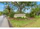 Community entrance sign with brick surround, attractive landscaping, and iron gate at 3399 Mermoor Dr # 301, Palm Harbor, FL 34685