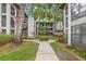 Exterior walkway showcasing manicured greenery leading to condos with lush landscaping and shade trees at 3399 Mermoor Dr # 301, Palm Harbor, FL 34685