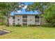 Three-story condo building with well-kept lawn and mature trees providing shade at 3399 Mermoor Dr # 301, Palm Harbor, FL 34685