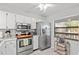 Well-lit kitchen featuring stainless steel appliances, white cabinets, and window views offering a pleasant cooking environment at 3399 Mermoor Dr # 301, Palm Harbor, FL 34685
