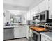 Bright kitchen featuring white cabinetry, stainless steel appliances, and tile countertops at 3399 Mermoor Dr # 301, Palm Harbor, FL 34685