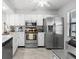 Bright kitchen featuring stainless steel appliances, white cabinetry, and a ceiling fan for a modern and functional space at 3399 Mermoor Dr # 301, Palm Harbor, FL 34685