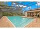 Community pool featuring a screened enclosure and clear blue water at 3399 Mermoor Dr # 301, Palm Harbor, FL 34685