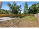 Expansive backyard with lush lawn, mature trees, and a wooden fence at 3910 W Iowa Ave, Tampa, FL 33616