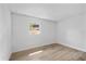 Bright bedroom featuring wood-look flooring and a window allowing natural light at 3910 W Iowa Ave, Tampa, FL 33616