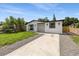 Inviting single-story home with a white exterior, dark trim, and a concrete driveway at 3910 W Iowa Ave, Tampa, FL 33616