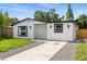 Charming single-story home features white siding, modern windows, and a well-manicured lawn at 3910 W Iowa Ave, Tampa, FL 33616