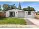 Charming home featuring white siding, black window trim, green lawn and walkway at 3910 W Iowa Ave, Tampa, FL 33616