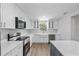 Modern kitchen featuring white cabinets, stainless steel appliances, and a farmhouse sink at 3910 W Iowa Ave, Tampa, FL 33616