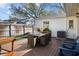 Backyard featuring wooden deck with dining table, lounge chairs, landscaping, and fenced perimeter at 4103 W Bay Villa Ave, Tampa, FL 33611