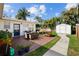 Charming backyard features a wooden deck with dining, grill, lush landscaping, shed, and privacy fence at 4103 W Bay Villa Ave, Tampa, FL 33611