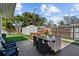 Landscaped backyard with wooden deck featuring a dining table, storage shed, and privacy fence at 4103 W Bay Villa Ave, Tampa, FL 33611