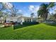 Picturesque backyard with a green lawn, mature trees, outdoor dining area, and partial view of the house at 4103 W Bay Villa Ave, Tampa, FL 33611