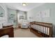 Charming Bedroom featuring a crib, rocking chair, and soft, neutral colors at 4103 W Bay Villa Ave, Tampa, FL 33611