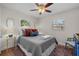 Cozy bedroom with a ceiling fan, wood-look floors, and a comfortable queen-size bed at 4103 W Bay Villa Ave, Tampa, FL 33611