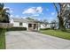 Charming home featuring a well-maintained lawn, mature trees, and a spacious driveway leading to the entrance at 4103 W Bay Villa Ave, Tampa, FL 33611