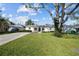 Inviting home with a well-manicured lawn, mature trees, and a long driveway leading to the residence at 4103 W Bay Villa Ave, Tampa, FL 33611