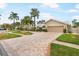 Brick driveway leads to a two-car garage, landscaped front yard and charming light-colored home at 4138 Saltwater Blvd, Tampa, FL 33615