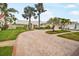 Brick driveway leads to a well-maintained light-colored home with a lush, landscaped yard at 4138 Saltwater Blvd, Tampa, FL 33615