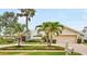 Charming front exterior with mature palms, paver driveway, lush lawn and a welcoming double door entry at 4138 Saltwater Blvd, Tampa, FL 33615