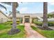 Inviting single-story house showcasing a brick pathway leading to the entrance with tropical landscaping at 4138 Saltwater Blvd, Tampa, FL 33615